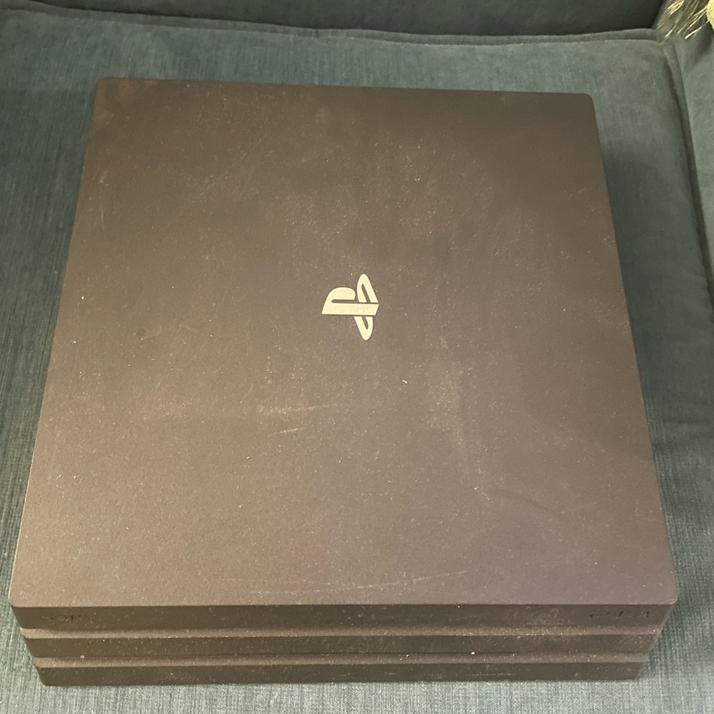 PlayStation 4 with 2 remote controllers and 3 games.